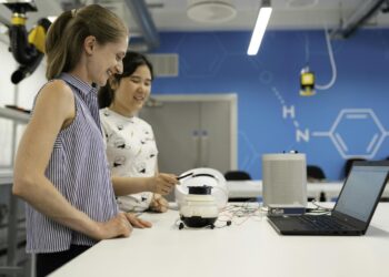 woman in white and black polka dot shirt holding white headphones
