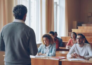 Professor teaching students in a lecture hall.